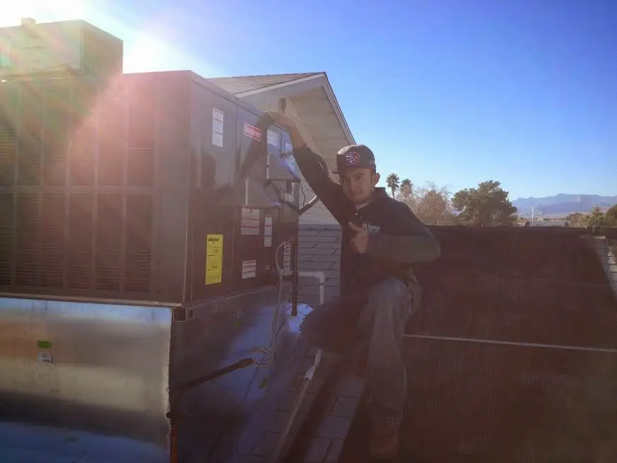 HVAC technician performing Boiler Repair on a rooftop unit in Kingston